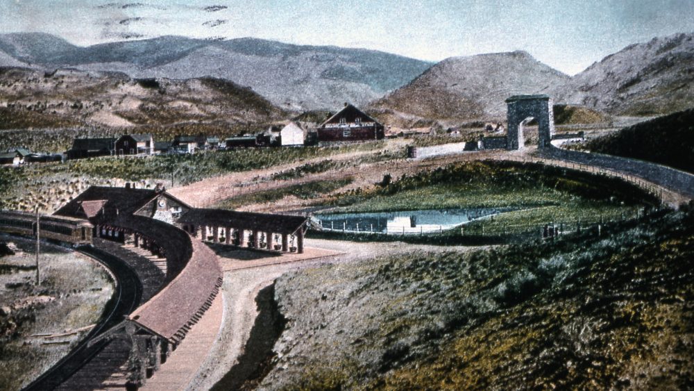 F.J. Haynes Postcard, undated. Roosevelt Arch and train depot in Gardiner, MT