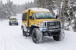 A modern-day snowcoach-a van with oversized tires that are underinflated to keep the vehicle from sinking into the snow.