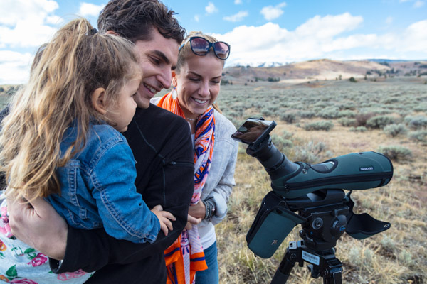 Family viewing wildlife through a scope on a private tour in Yellowstone