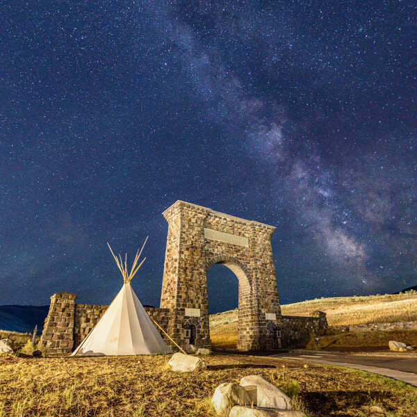 Roosevelt Arch and Milky Way 2026 Yellowstone Forever Calendar Contest winning image of the Milky Way and stars over the Roosevelt Arch and teepee.